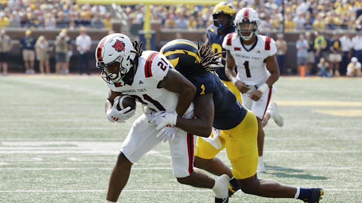 Sep 14, 2024; Ann Arbor, Michigan, USA;  Arkansas State Red Wolves running back Zak Wallace (21) is tackled by Michigan Wolverines linebacker Jaishawn Barham (1) during the first half at Michigan Stadium. Mandatory Credit: Rick Osentoski-Imagn Images