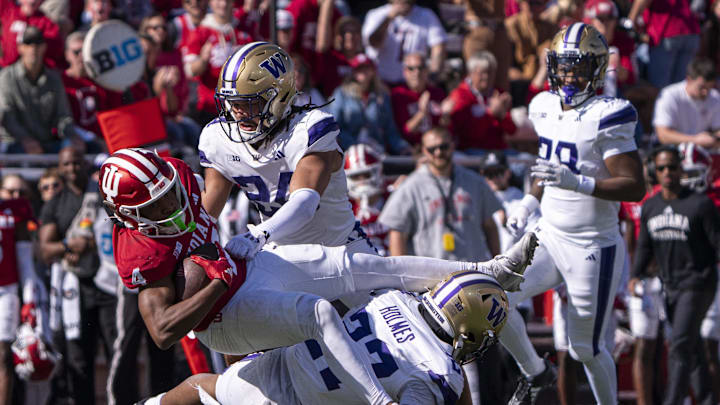 Oct 26, 2024; Bloomington, Indiana, USA; Indiana Hoosiers Myles Price (4) is tackled by Washington Huskies safety Vincent Holmes (27) during the third quarter at Memorial Stadium. Mandatory Credit: Jacob Musselman-Imagn Images