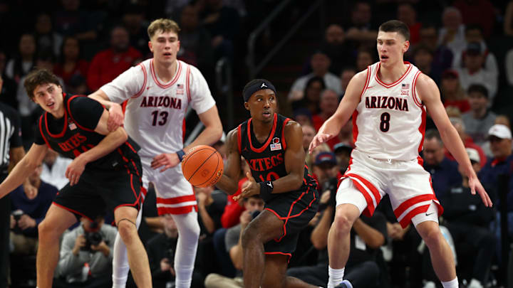 Dec 20, 2025; Phoenix, Arizona, USA; San Diego State Aztecs guard BJ Davis (10) moves the ball against the Arizona Wildcats center Motiejus Krivas (13) and forward Ivan Kharchenkov (8) in the second half during the Hall of Fame Series at Mortgage Matchup Center. Mandatory Credit: Mark J. Rebilas-Imagn Images
