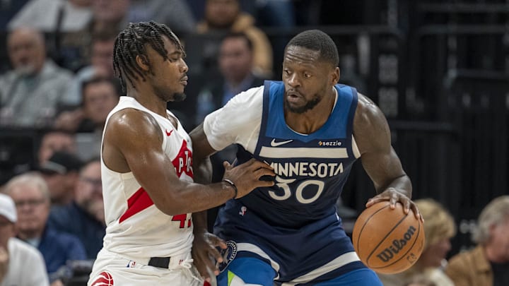 Oct 26, 2024; Minneapolis, Minnesota, USA; Minnesota Timberwolves forward Julius Randle (30) backs towards the basket as Toronto Raptors guard Davion Mitchell (45) plays defense in the second half at Target Center. Mandatory Credit: Jesse Johnson-Imagn Images