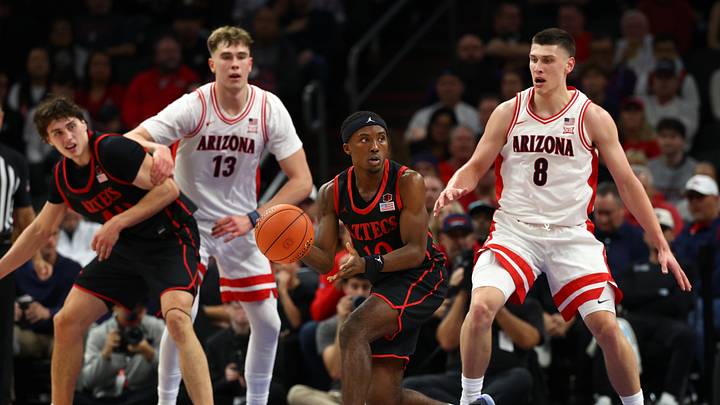Dec 20, 2025; Phoenix, Arizona, USA; San Diego State Aztecs guard BJ Davis (10) moves the ball against the Arizona Wildcats center Motiejus Krivas (13) and forward Ivan Kharchenkov (8) in the second half during the Hall of Fame Series at Mortgage Matchup Center. Mandatory Credit: Mark J. Rebilas-Imagn Images