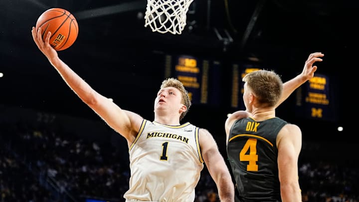 Michigan center Danny Wolf (1) makes a layup against Iowa guard Josh Dix (4) during the second half at Crisler Center in Ann Arbor on Saturday, Dec. 7, 2024.