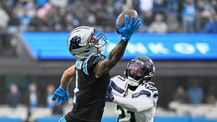 Dec 28, 2025; Charlotte, North Carolina, USA; Carolina Panthers wide receiver Tetairoa McMillan (4) extends but cannot catch a pass against Seattle Seahawks cornerback Devon Witherspoon (21) during the second quarter at Bank of America Stadium. Mandatory Credit: Bob Donnan-Imagn Images