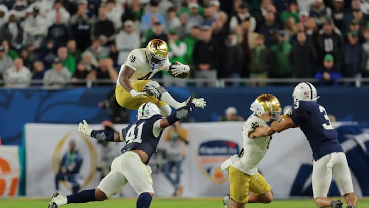 Jan 9, 2025; Miami, FL, USA; (Editors Note: Caption Correction) Notre Dame Fighting Irish running back Jeremiyah Love (4) leaps over Penn State Nittany Lions linebacker Kobe King (41) in the second half in the Orange Bowl at Hard Rock Stadium. Mandatory Credit: Sam Navarro-Imagn Images