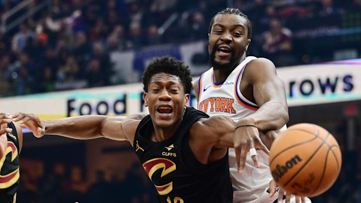 Feb 21, 2025; Cleveland, Ohio, USA;  New York Knicks center Ariel Hukporti (55) goes for a rebound against Cleveland Cavaliers forward De'Andre Hunter (12) during the first half at Rocket Arena. Mandatory Credit: Ken Blaze-Imagn Images