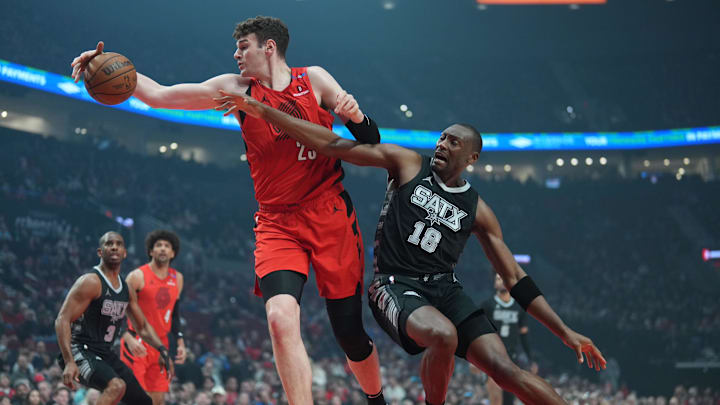 Apr 6, 2025; Portland, Oregon, USA; Portland Trail Blazers center Donovan Clingan (23) handles the ball against San Antonio Spurs center Bismack Biyombo (18) during the first half at Moda Center. Mandatory Credit: Soobum Im-Imagn Images Apr 6, 2025; Portland, Oregon, USA; Portland Trail Blazers center Donovan Clingan (23) handles the ball against San Antonio Spurs center Bismack Biyombo (18) during the first half at Moda Center. Mandatory Credit: Soobum Im-Imagn Images
