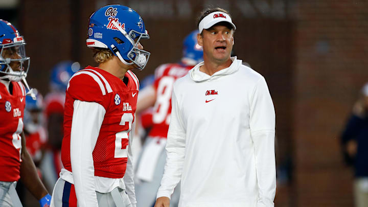 Oct 28, 2023; Oxford, Mississippi, USA; Mississippi Rebels head coach Lane Kiffin (right) talks with quarterback Jaxson Dart (2) during warm ups prior to the game against the Vanderbilt Commodores at Vaught-Hemingway Stadium. Mandatory Credit: Petre Thomas-Imagn Images