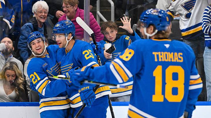 Oct 10, 2026; St. Louis, Missouri, USA; St. Louis Blues right wing Jimmy Snuggerud (21) celebrates with defenseman Brandon Carlo (25) and center Robert Thomas (18) after scoring against the Columbus Blue Jackets during the second period at Enterprise Center. Mandatory Credit: Jeff Curry-Imagn Images