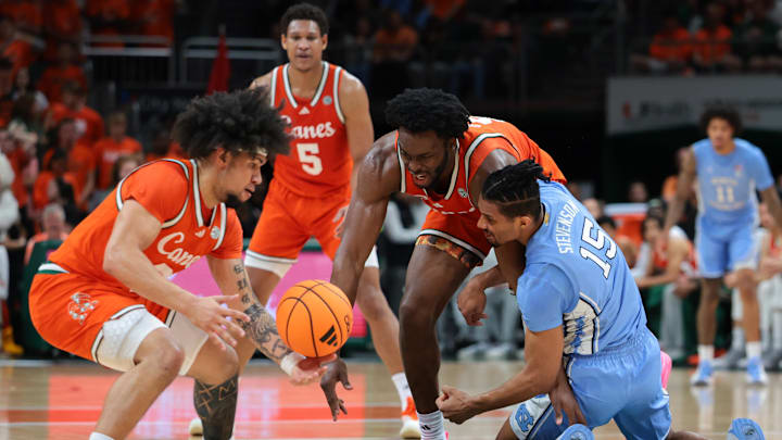 Feb 10, 2026; Coral Gables, Florida, USA; Miami Hurricanes center Ernest Udeh Jr. (8) and North Carolina Tar Heels forward Jarin Stevenson (15) battle for a loose ball during the first half at Watsco Center. Mandatory Credit: Sam Navarro-Imagn Images