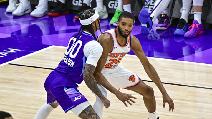 Nov 23, 2024; Salt Lake City, Utah, USA; New York Knicks guard/forward Mikal Bridges (25) dribbles the ball against Utah Jazz guard Jordan Clarkson (00) during the second half at the Delta Center. Mandatory Credit: Christopher Creveling-Imagn Images