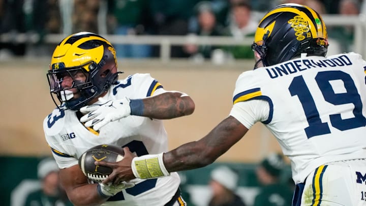 Oct 25, 2025; East Lansing, Michigan, USA; Michigan Wolverines running back Jordan Marshall (23) takes the handoff from quarterback Bryce Underwood (19) against the Michigan State Spartans at Spartan Stadium. Mandatory Credit: Brendan Mullin-Imagn Images