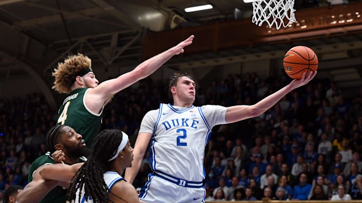Dec 17, 2024; Durham, North Carolina, USA;  Duke basketball forward Cooper Flagg (2) lays the ball up in front of George Mason Patriots guard Brayden O'Connor (4) during the second half at Cameron Indoor Stadium. 
