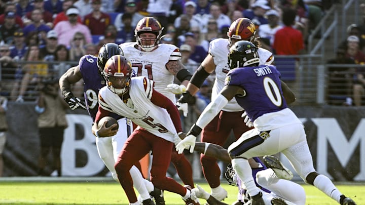 Oct 13, 2024; Baltimore, Maryland, USA; Baltimore Ravens defensive end Yannick Ngakoue (91) pulls down Washington Commanders quarterback Jayden Daniels (5) by his jersey for a sack during the second half at M&T Bank Stadium. Mandatory Credit: Tommy Gilligan-Imagn Images Oct 13, 2024; Baltimore, Maryland, USA; Baltimore Ravens defensive end Yannick Ngakoue (91) pulls down Washington Commanders quarterback Jayden Daniels (5) by his jersey for a sack during the second half at M&T Bank Stadium. Mandatory Credit: Tommy Gilligan-Imagn Images