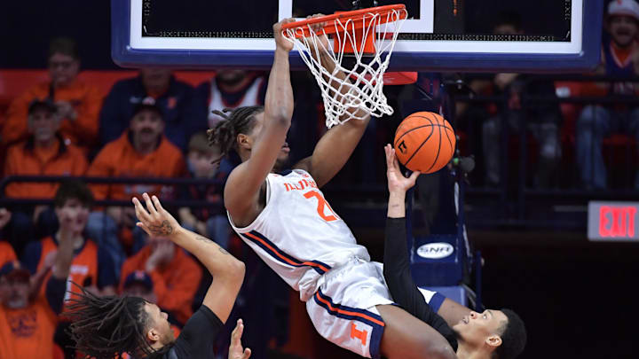 Dec 29, 2024; Champaign, Illinois, USA;  Illinois Fighting Illini forward Morez Johnson Jr. (21) dunks the ball over Chicago State Cougars forward CJ Delancy (20) and Noble Crawford (11) during the second half at State Farm Center. Mandatory Credit: Ron Johnson-Imagn Images