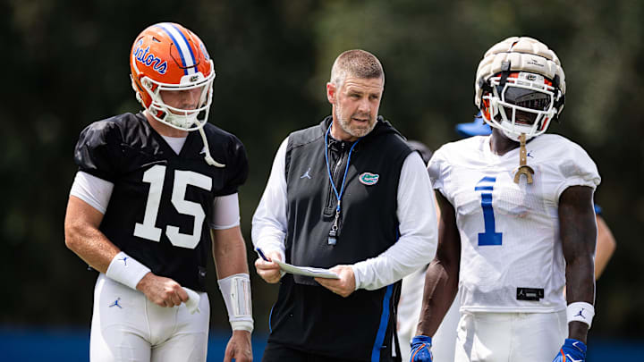 Florida Gators head coach Billy Napier talks with Florida Gators quarterback Graham Mertz (15) and Florida Gators running back Montrell Johnson Jr. (1) during fall football practice at Heavener Football Complex at the University of Florida in Gainesville, FL on Thursday, August 1, 2024. [Matt Pendleton/Gainesville Sun]