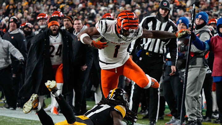 Bengals Ja'Marr Chase (1) leaps over a Steelers player during their game against the Steelers at Acrisure Stadium on Saturday January 4, 2025. The Bengals lead the game at halftime with a score of 13-7.