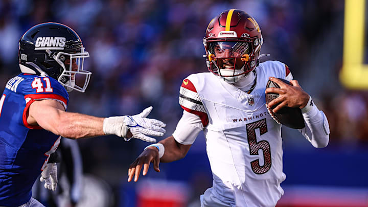 Nov 3, 2024; East Rutherford, New Jersey, USA; Washington Commanders quarterback Jayden Daniels (5) scrambles away from New York Giants linebacker Micah McFadden (41) during the first half at MetLife Stadium. Mandatory Credit: Vincent Carchietta-Imagn Images