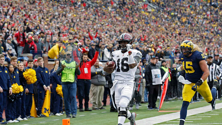 Ohio State Buckeyes quarterback J.T. Barrett (16) scores a rushing touchdown against Michigan Wolverines defensive lineman Chase Winovich (15) during the 1st half of their game at Michigan Stadium on November 25, 2017.
