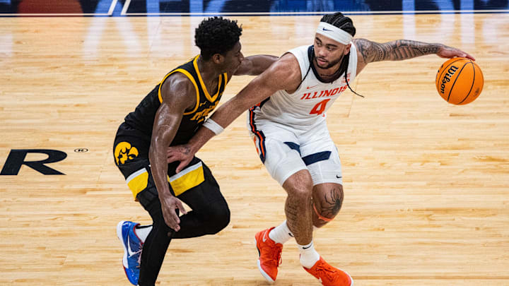 Mar 13, 2025; Indianapolis, IN, USA;  Illinois Fighting Illini guard Kylan Boswell (4) dribbles  the ball while Iowa Hawkeyes guard Josh Dix (4) defends in the first half at Gainbridge Fieldhouse. Mandatory Credit: Trevor Ruszkowski-Imagn Images