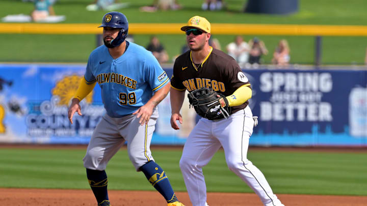 Feb 23, 2026; Peoria, Arizona, USA;  San Diego Padres first baseman Ty France (4) keeps Milwaukee Brewers catcher Gary Sánchez (99) close to the bag in the first inning at Peoria Sports Complex. Mandatory Credit: Jayne Kamin-Oncea-Imagn Images