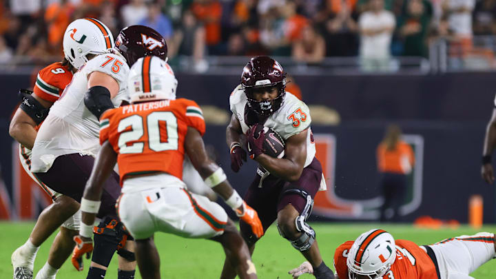 Sep 27, 2024; Miami Gardens, Florida, USA; Virginia Tech Hokies running back Bhayshul Tuten (33) runs with the football past Miami Hurricanes defensive lineman Akheem Mesidor (3) during the fourth quarter at Hard Rock Stadium. Mandatory Credit: Sam Navarro-Imagn Images