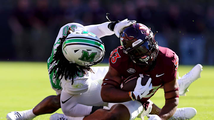 Sep 7, 2024; Blacksburg, Virginia, USA; Virginia Tech Hokies running back Bhayshul Tuten (33) is tackled by Marshall Thundering Herd linebacker Jaden Yates (30) during the first quarter at Lane Stadium. Mandatory Credit: Peter Casey-Imagn Images