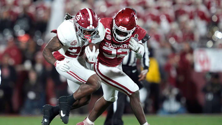Alabama Crimson Tide running back Jamarion Miller (26) runs beside Oklahoma Sooners defensive lineman R Mason Thomas (32) during a first-round College Football Playoff game between the University of Oklahoma Sooners (OU) and the Alabama Crimson Tide at Gaylord Family – Oklahoma Memorial Stadium in Norman, Okla., Friday, Dec. 19, 2025. Alabama won 34-24.