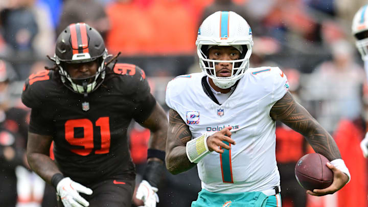 Miami Dolphins quarterback Tua Tagovailoa (1) runs with the ball as Cleveland Browns defensive end Alex Wright (91) defends during the first half at Huntington Bank Field. Miami Dolphins quarterback Tua Tagovailoa (1) runs with the ball as Cleveland Browns defensive end Alex Wright (91) defends during the first half at Huntington Bank Field.