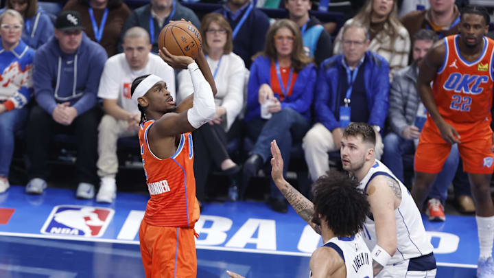 Dec 10, 2024; Oklahoma City, Oklahoma, USA; Oklahoma City Thunder guard Shai Gilgeous-Alexander (2) shoots over Dallas Mavericks guard Luka Doncic (77) and center Dereck Lively II (2) during the first quarter at Paycom Center. Mandatory Credit: Alonzo Adams-Imagn Images