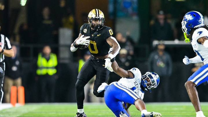 Nov 22, 2025; Nashville, Tennessee, USA; Vanderbilt Commodores wide receiver Junior Sherrill (0) hurdles over Kentucky Wildcats defensive back Cam Dooley (18) during the second half at FirstBank Stadium. Mandatory Credit: Steve Roberts-Imagn Images Nov 22, 2025; Nashville, Tennessee, USA; Vanderbilt Commodores wide receiver Junior Sherrill (0) hurdles over Kentucky Wildcats defensive back Cam Dooley (18) during the second half at FirstBank Stadium. Mandatory Credit: Steve Roberts-Imagn Images