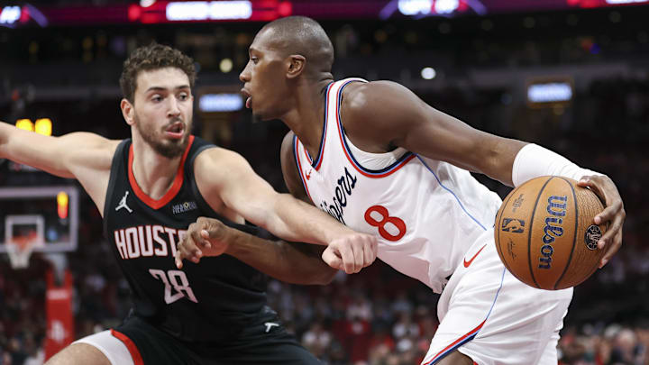 Nov 15, 2024; Houston, Texas, USA; Los Angeles Clippers guard Kris Dunn (8) drives with the ball as Houston Rockets center Alperen Sengun (28) defends during the first quarter at Toyota Center. Mandatory Credit: Troy Taormina-Imagn Images