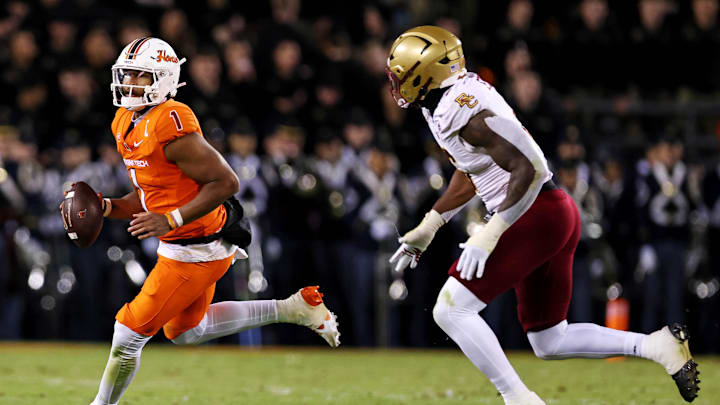 Oct 17, 2024; Blacksburg, Virginia, USA; Virginia Tech Hokies quarterback Kyron Drones (1) runs the ball against Boston College Eagles defensive end Donovan Ezeiruaku (6) during the second quarter at Lane Stadium. Mandatory Credit: Peter Casey-Imagn Images