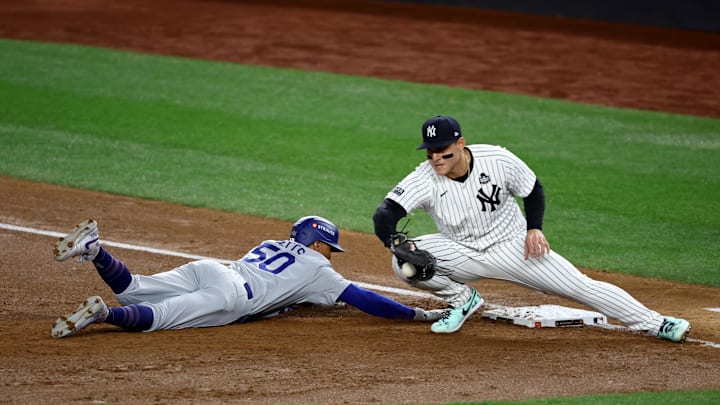 Oct 28, 2024; New York, New York, USA; Los Angeles Dodgers shortstop Mookie Betts (50) slides back safely under the tag of New York Yankees first baseman Anthony Rizzo (48) during the third inning in game three of the 2024 MLB World Series at Yankee Stadium. Mandatory Credit: Vincent Carchietta-Imagn Images