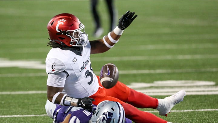 Nov 23, 2024; Manhattan, Kansas, USA; Kansas State Wildcats wide receiver Tre Spivey (12) loses the ball after being hit by Cincinnati Bearcats linebacker Simeon Coleman (31) during the third quarter at Bill Snyder Family Football Stadium. Mandatory Credit: Scott Sewell-Imagn Images
