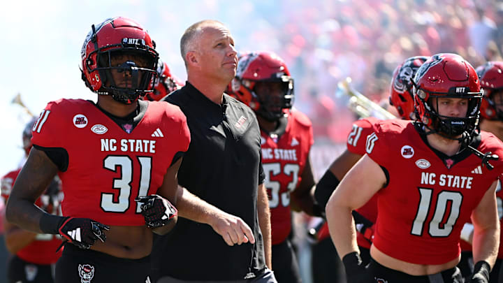 Oct 7, 2023; Raleigh, North Carolina, USA; North Carolina State Wolfpack head coach Dave Doeren (center) leads his team onto the field prior to a game against the Marshall Thundering Herd at Carter-Finley Stadium. Mandatory Credit: Rob Kinnan-Imagn Images