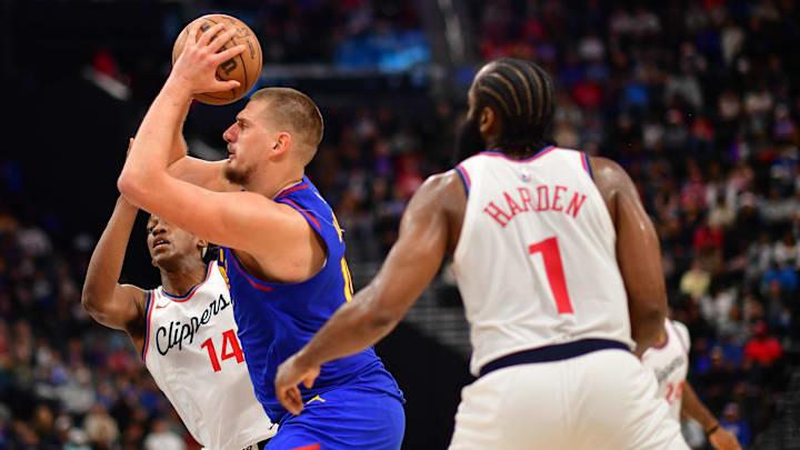 Denver Nuggets center Nikola Jokic (15) moves to the basket against Los Angeles Clippers guard James Harden (1) and guard Terance Mann (14) during the second half at Intuit Dome. Mandatory Credit: Gary A. Vasquez-Imagn Images