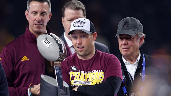 Dec 7, 2024; Arlington, TX, USA; Arizona State Sun Devils head coach Kenny Dillingham looks at the trophy after winning the Big 12 Championship game against the Iowa State Cyclones at AT&T Stadium. Mandatory Credit: Tim Heitman-Imagn Images