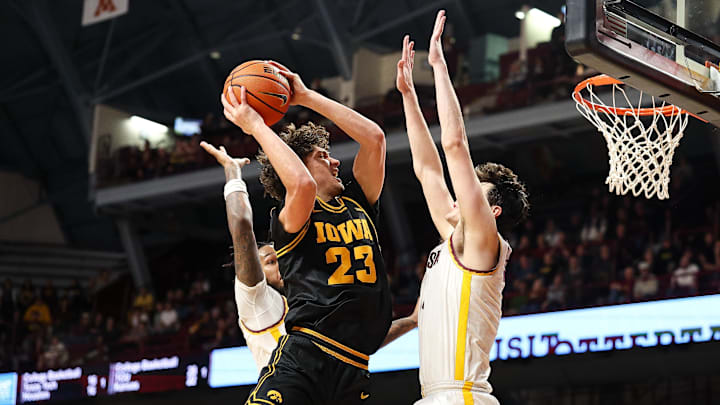 Jan 6, 2026; Minneapolis, Minnesota, USA; Iowa Hawkeyes guard Isaia Howard (23) shoots against Minnesota Golden Gophers forward Bobby Durkin (3) during the second half at Williams Arena. Mandatory Credit: Matt Krohn-Imagn Images