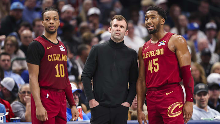 Jan 3, 2025; Dallas, Texas, USA; Cleveland Cavaliers assistant coach Mike Gerrity speaks with Cleveland Cavaliers guard Darius Garland (10) and Cleveland Cavaliers guard Donovan Mitchell (45) during the first half against the Dallas Mavericks at American Airlines Center. Mandatory Credit: Kevin Jairaj-Imagn Images Jan 3, 2025; Dallas, Texas, USA; Cleveland Cavaliers assistant coach Mike Gerrity speaks with Cleveland Cavaliers guard Darius Garland (10) and Cleveland Cavaliers guard Donovan Mitchell (45) during the first half against the Dallas Mavericks at American Airlines Center. Mandatory Credit: Kevin Jairaj-Imagn Images