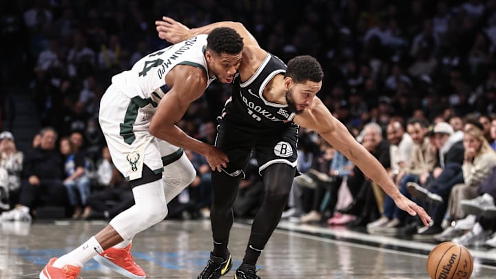 Oct 27, 2024; Brooklyn, New York, USA;  Milwaukee Bucks forward Giannis Antetokounmpo (34) and Brooklyn Nets guard Ben Simmons (10) fight for a loose ball in the fourth quarter at Barclays Center. Mandatory Credit: Wendell Cruz-Imagn Images