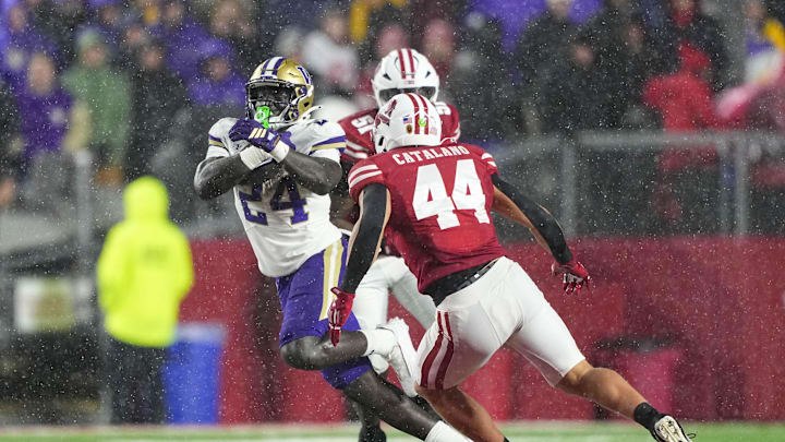 Nov 8, 2025; Madison, Wisconsin, USA; Washington Huskies running back Adam Mohammed (24) rushes with the football as Wisconsin Badgers linebacker Cooper Catalano (44) defends during the fourth quarter at Camp Randall Stadium. Mandatory Credit: Jeff Hanisch-Imagn Images Nov 8, 2025; Madison, Wisconsin, USA; Washington Huskies running back Adam Mohammed (24) rushes with the football as Wisconsin Badgers linebacker Cooper Catalano (44) defends during the fourth quarter at Camp Randall Stadium. Mandatory Credit: Jeff Hanisch-Imagn Images