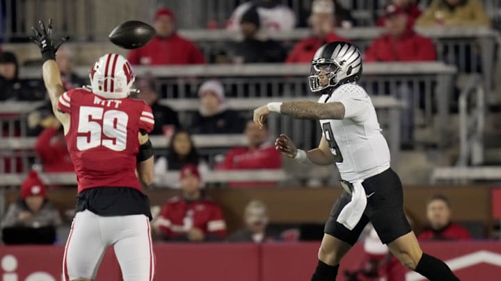 Oregon quarterback Dillon Gabriel (8) is pressured by Wisconsin linebacker Aaron Witt (59) during the first quarter of their game Saturday, November 16, 2024 at Camp Randall Stadium in Madison, Wisconsin.