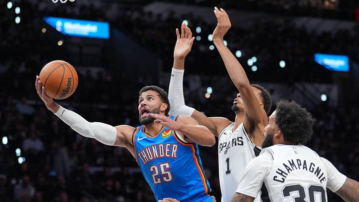 Oct 20, 2026; San Antonio, Texas, USA; Oklahoma City Thunder guard Ajay Mitchell (25) shoots in front of San Antonio Spurs forwards Victor Wembanyama (1) and Julian Champagnie (30) in the first half at Frost Bank Center. Oct 20, 2026; San Antonio, Texas, USA; Oklahoma City Thunder guard Ajay Mitchell (25) shoots in front of San Antonio Spurs forwards Victor Wembanyama (1) and Julian Champagnie (30) in the first half at Frost Bank Center.