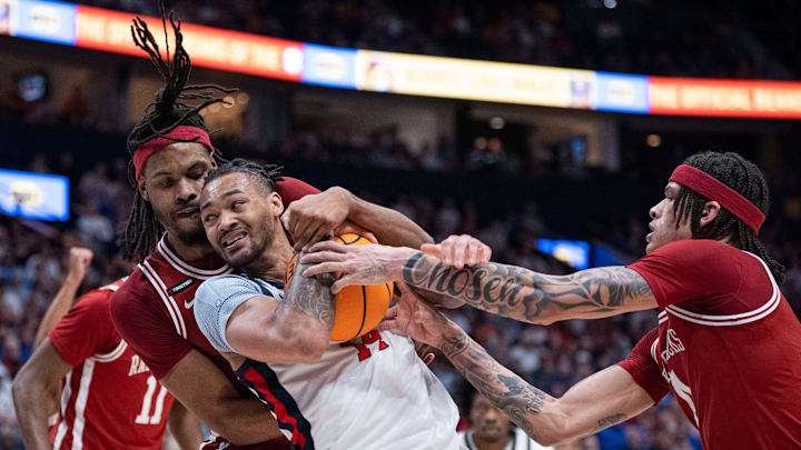Arkansas Razorbacks forward Jonas Aidoo (9) guards Mississippi Rebels guard Dre Davis (14) while Arkansas Razorbacks guard Ayden Kelley (14) defends during their second round game of the SEC Men's Basketball Tournament at Bridgestone Arena in Nashville, Tenn., Thursday, March 13, 2025.