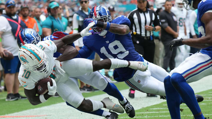 Miami Dolphins wide receiver Tyreek Hill (10) gets knocked out of bounds by New York Giants cornerback Deonte Banks (25) and safety Isaiah Simmons (19) during the first half of an NFL game at Hard Rock Stadium in Miami Gardens, October 8, 2023. Miami Dolphins wide receiver Tyreek Hill (10) gets knocked out of bounds by New York Giants cornerback Deonte Banks (25) and safety Isaiah Simmons (19) during the first half of an NFL game at Hard Rock Stadium in Miami Gardens, October 8, 2023.