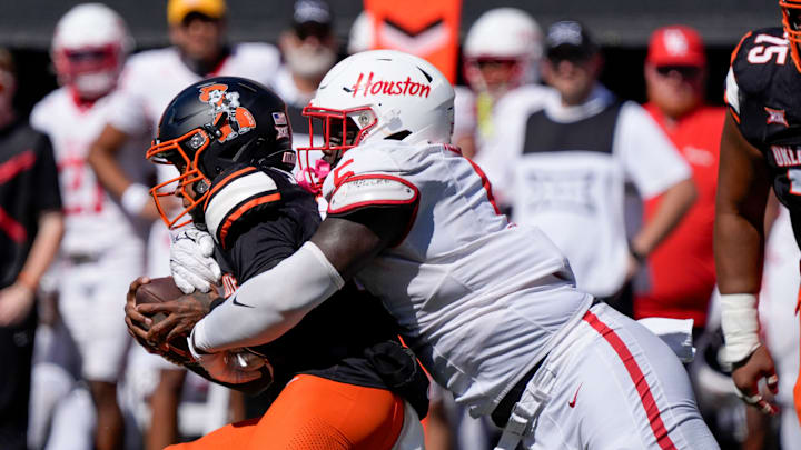 Houston Cougars defensive lineman Carlos Allen (5) brings down Oklahoma State Cowboys quarterback Sam Jackson V (18) during a college football game between the Oklahoma State Cowboys (OSU) and the Houston Cougars at Boone Pickens Stadium in Stillwater, Okla., Saturday, Oct. 11, 2025. Houston won 39-17. Houston Cougars defensive lineman Carlos Allen (5) brings down Oklahoma State Cowboys quarterback Sam Jackson V (18) during a college football game between the Oklahoma State Cowboys (OSU) and the Houston Cougars at Boone Pickens Stadium in Stillwater, Okla., Saturday, Oct. 11, 2025. Houston won 39-17.