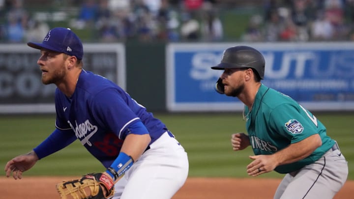 Seattle Mariners left fielder Cooper Hummel (21) leads off first base as Los Angeles Dodgers first baseman Michael Busch (83) covers the bag during the third inning at Camelback Ranch-Glendale in 2023.