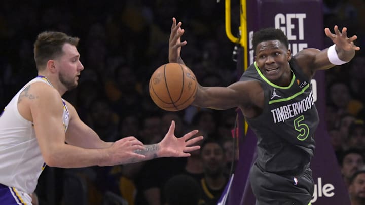 Doncic and Edwards reach for a loose ball. 