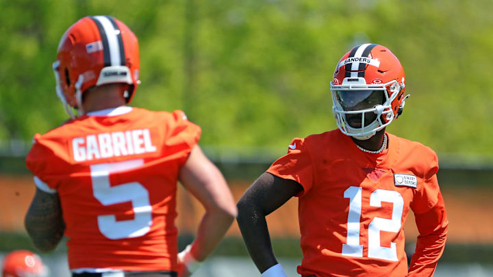 Cleveland Browns quarterback Shedeur Sanders (12) watches quarterback Dillon Gabriel (5) during day two of NFL rookie minicamp at the Cleveland Browns training facility on Saturday, May 10, 2025, in Berea, Ohio.