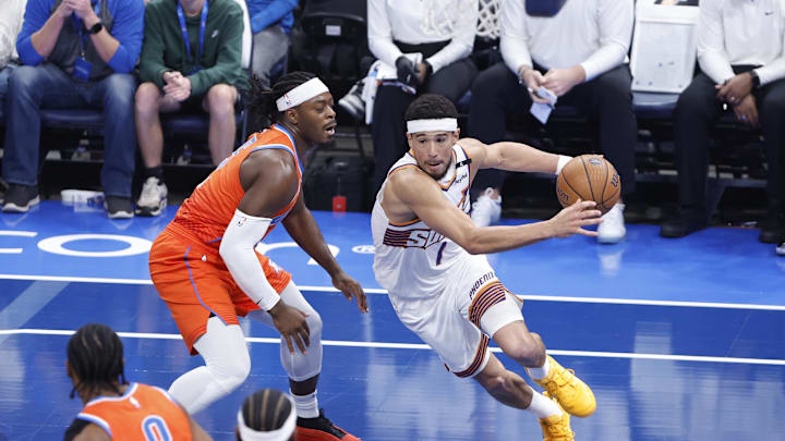 Phoenix Suns guard Devin Booker drives to the basket beside Oklahoma City Thunder guard Luguentz Dort.